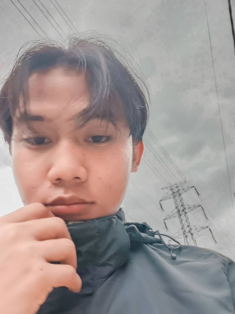 Outdoor selfie of Alfian Nur Usyaid wearing a dark jacket